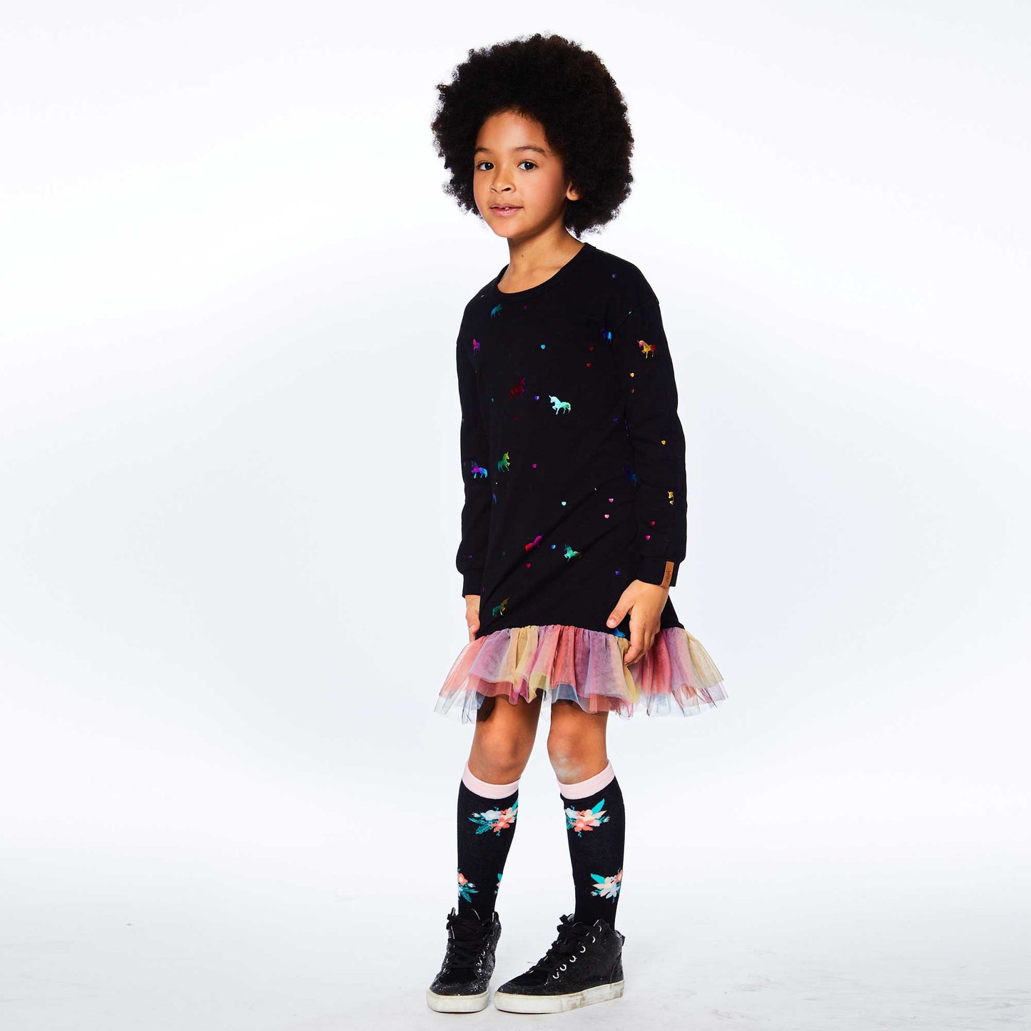 Casual with an ultra-girly twist, our Long Sleeve Dress With Mesh Frill is perfect for any party or family outing.  This dress is made from soft stretch cotton and features long sleeves, a round neckline, and an allover rainbow foil unicorn print. A rainbow mesh frill at the hem makes it an instant favorite!