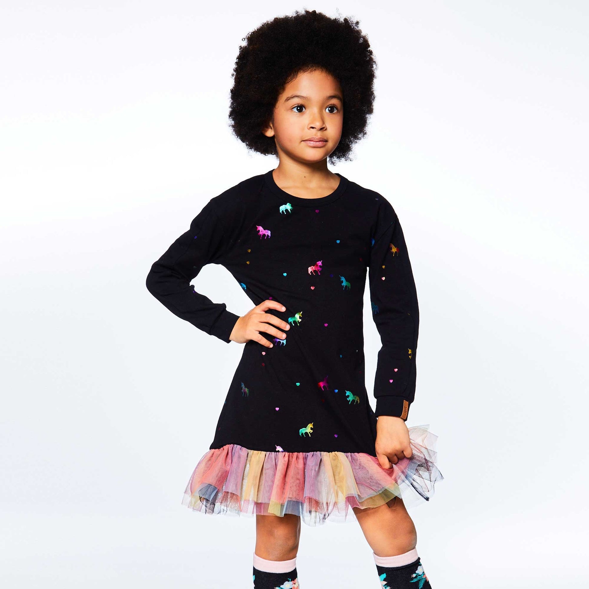 Casual with an ultra-girly twist, our Long Sleeve Dress With Mesh Frill is perfect for any party or family outing.  This dress is made from soft stretch cotton and features long sleeves, a round neckline, and an allover rainbow foil unicorn print. A rainbow mesh frill at the hem makes it an instant favorite!