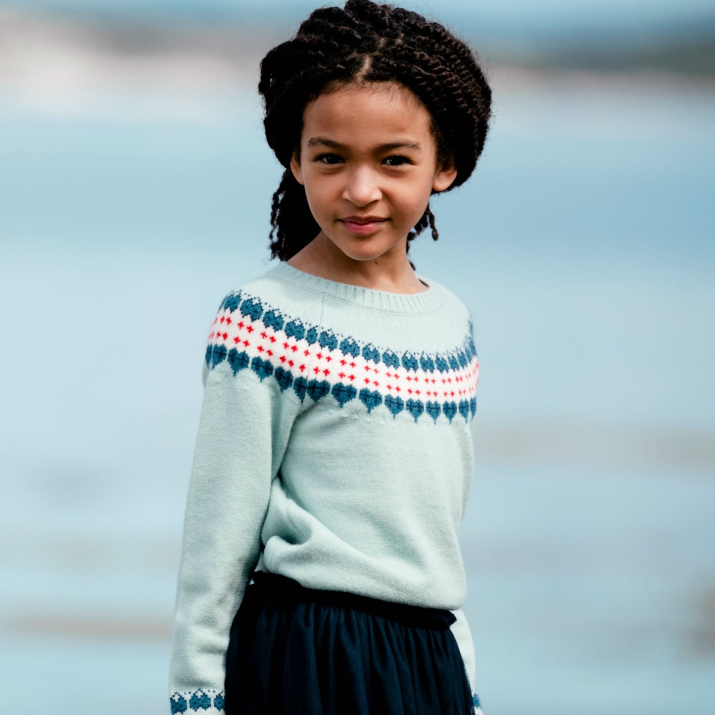 A Fair Isle pattern adds ski-inspired style to our Long Sleeve Knitted Sweater Light Blue and Red.  This pullover sweater is made from an acrylic/nylon/poly blend and features long raglan sleeves, a round neckline, and a Nordic pattern across the chest and sleeves. A rib knit hem and contrast cuffs complete the look!